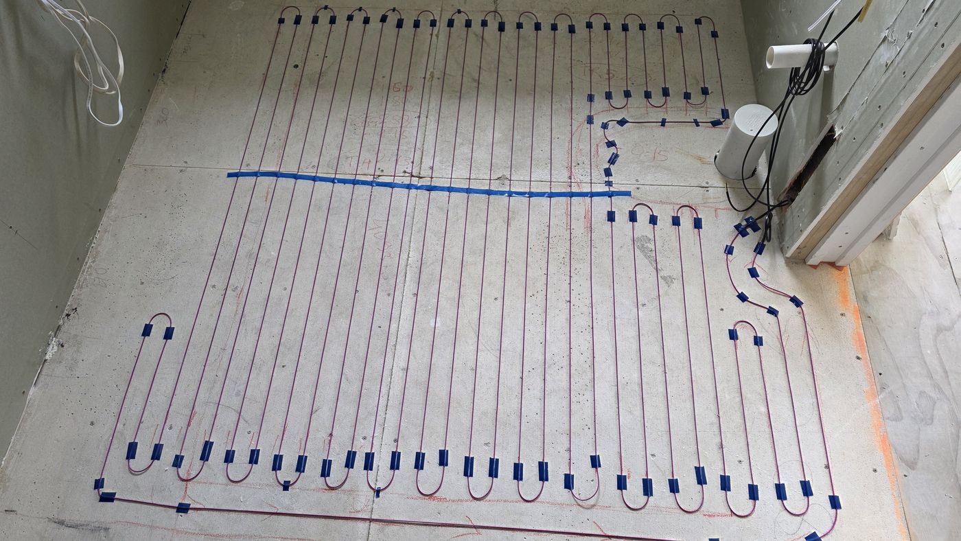 Electric underfloor heating by Floorheat NZ — the heating cable laid out across a bathroom floor before the screed goes on, the same system we fit across North Shore