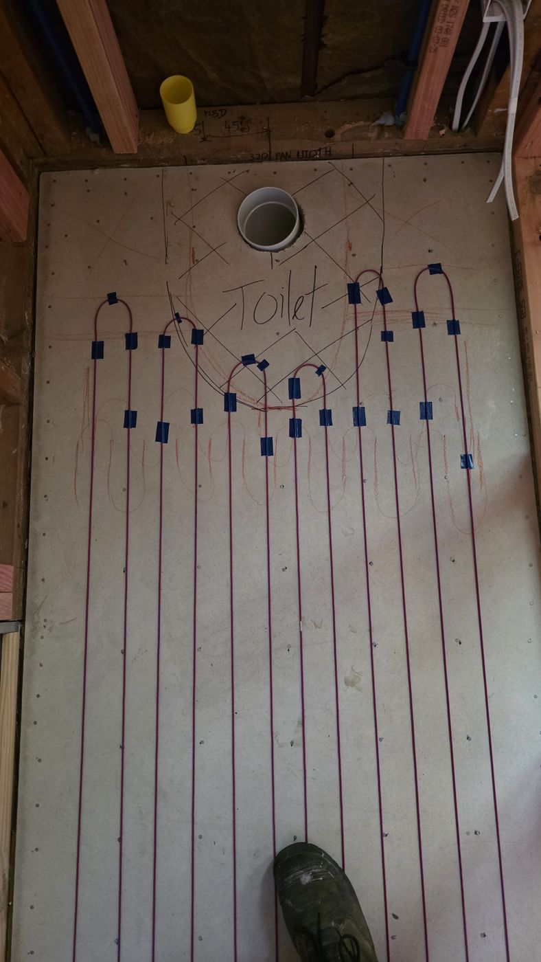 Electric underfloor heating by Floorheat NZ — the heating cable laid out across a bathroom floor before the screed goes on, the same system we fit across North Shore