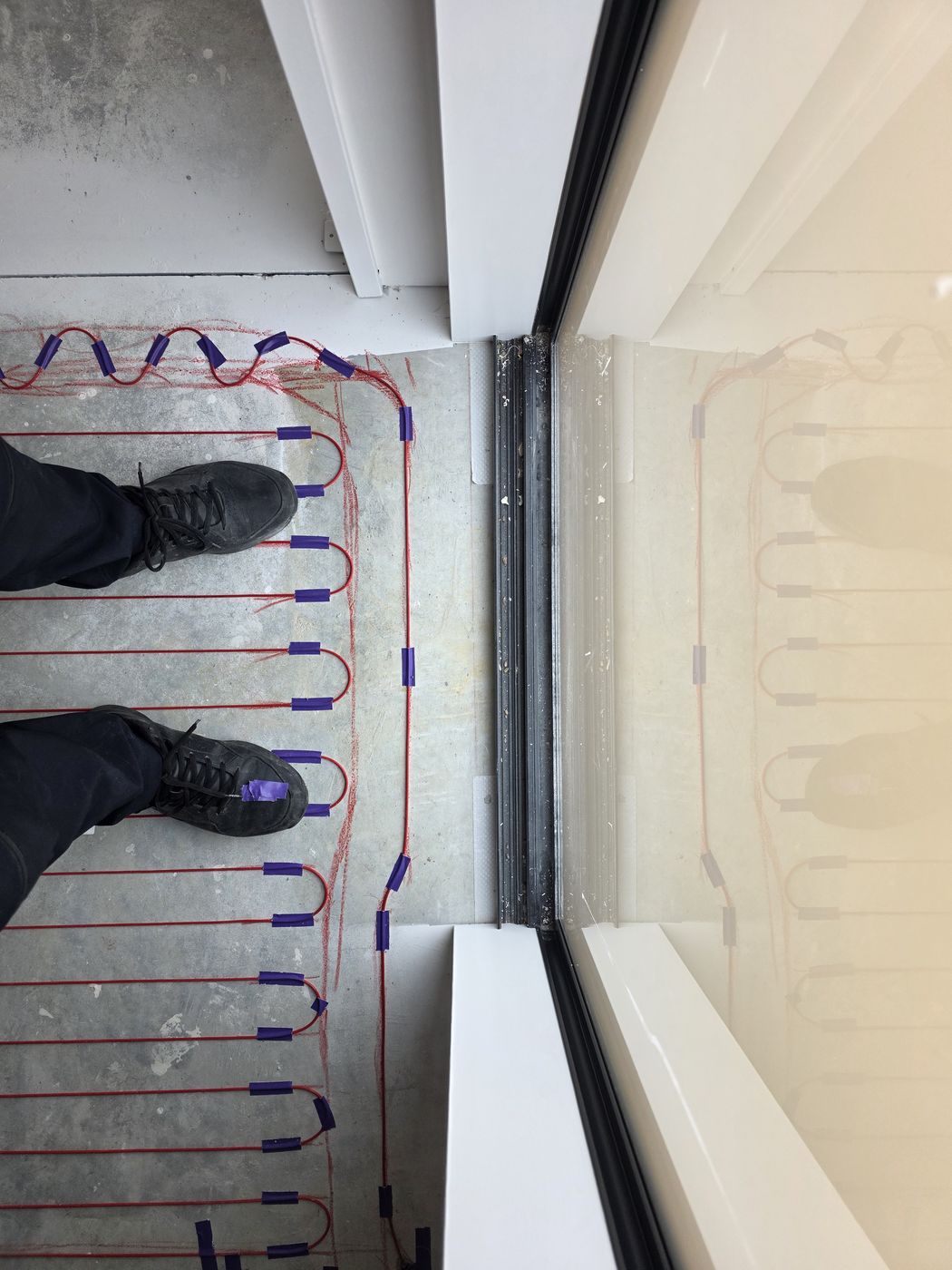 Electric underfloor heating by Floorheat NZ — the heating cable laid out across a bathroom floor before the screed goes on, the same system we fit across East Auckland
