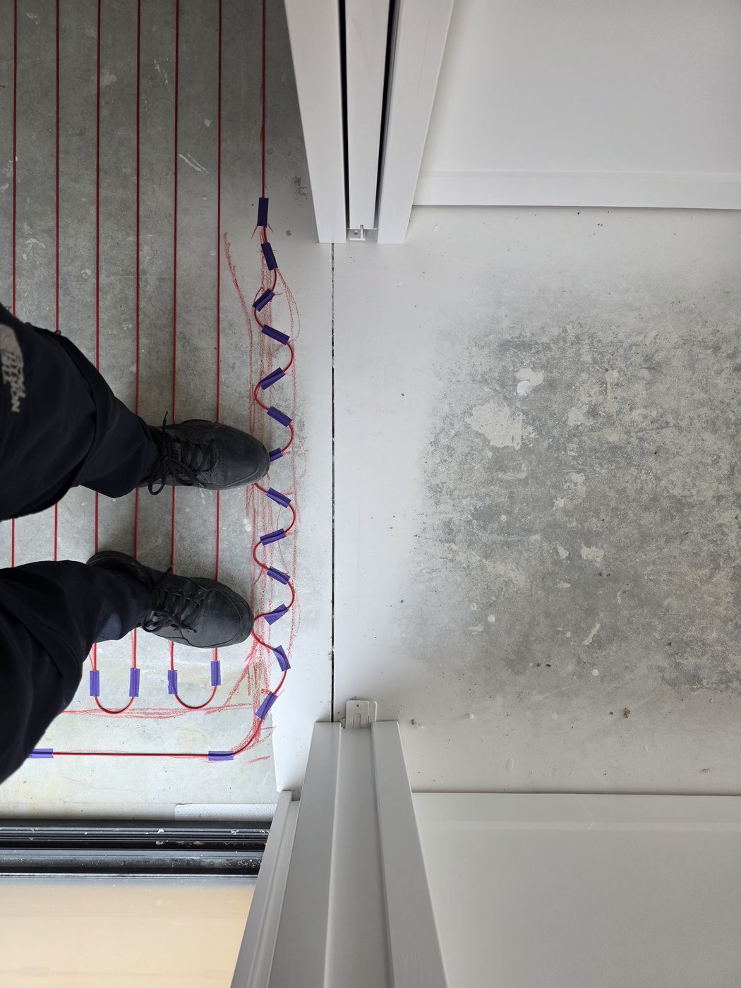 Electric underfloor heating by Floorheat NZ — the heating cable laid out across a bathroom floor before the screed goes on, the same system we fit across East Auckland